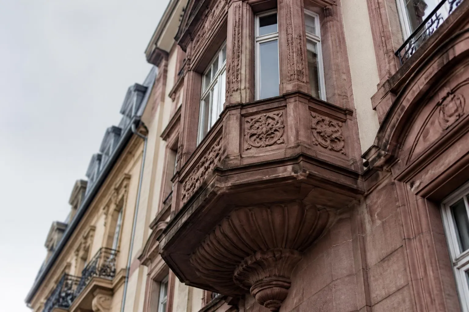 Façade d'un immeuble de la Neustadt de Strasbourg, grès rose et bow-window, au-dessus d'une rue vide